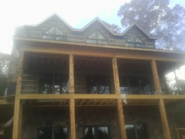 Dormers and porch framing on a large log home under construction — Roof Coating work by our crew in Rapidan
